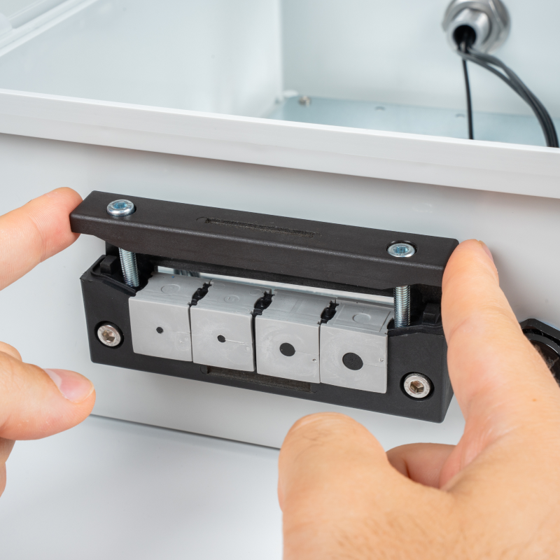 Fitting cable insert plugs into the cable entry frame of the Sixfab Edge Outdoor Kit