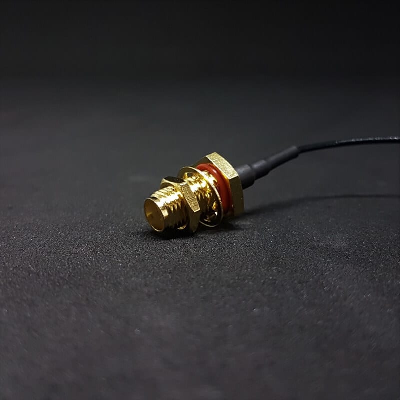 Waterproof SMA-to-u.FL feedthrough cable mounted through an outdoor IoT enclosure wall